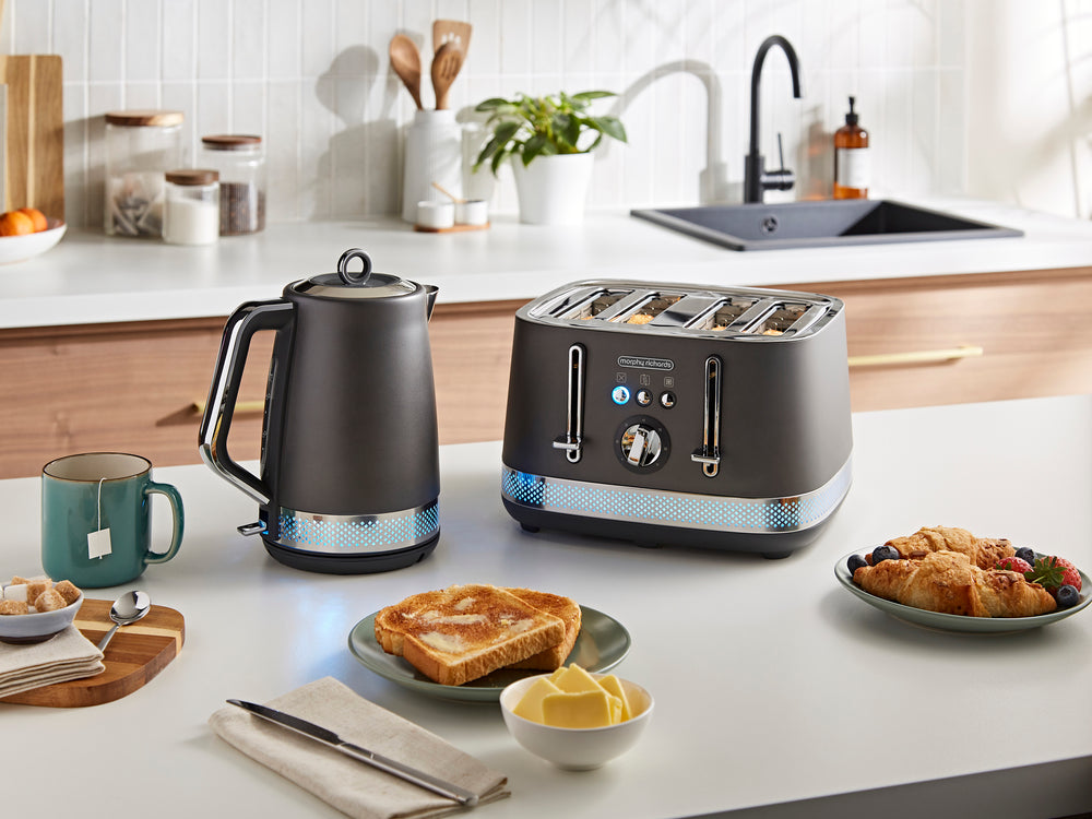 Kitchen scene with a toaster, kettle, and breakfast items on a counter.