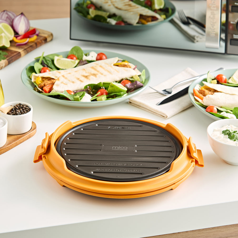 Microwave Round Grill with a chicken fajita on a plate in the background 