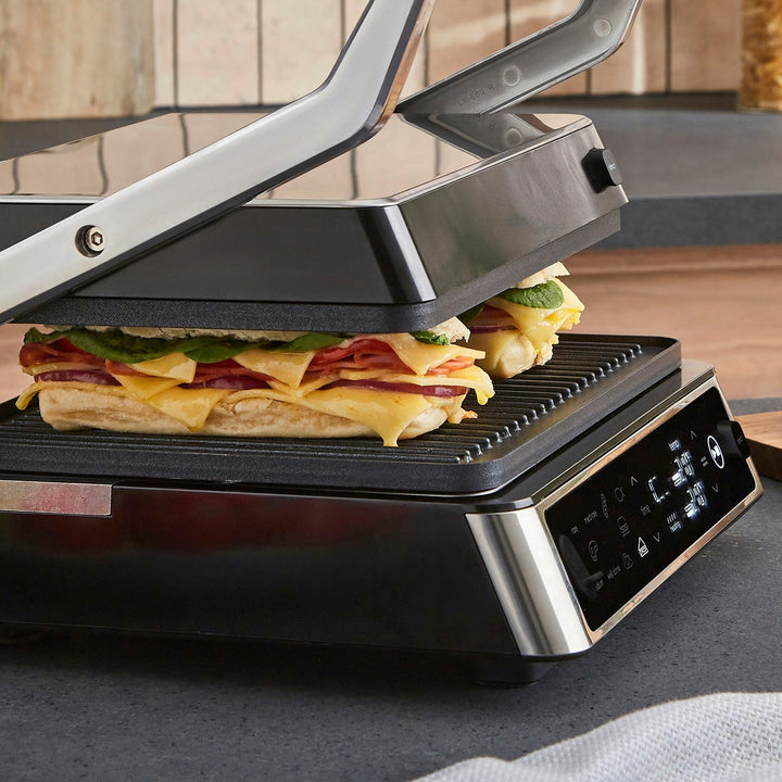 Sandwich being made in a modern sandwich maker with digital display.