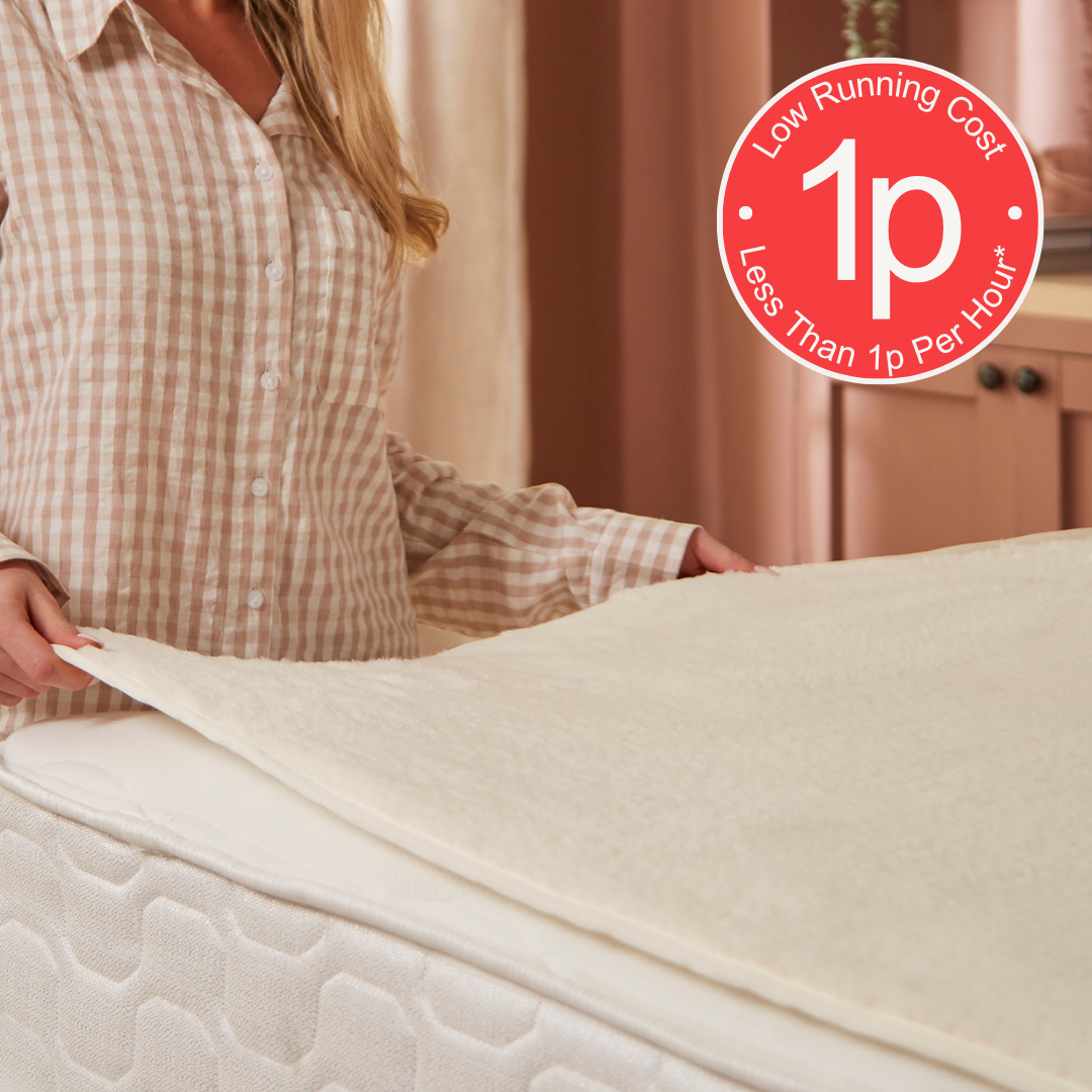 Person adjusting a electric heated under blanket with a 'Low Running Cost, Less Than 1p Per Hour' label.